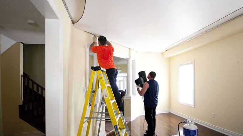 Мужчины выполняют демонтаж натяжного потолка