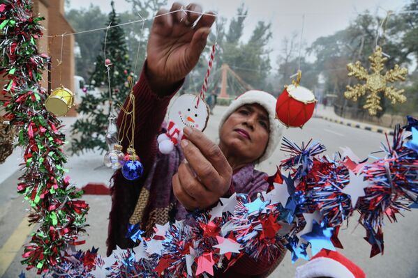 Женщина расставляет украшения для предстоящих рождественских торжеств в соборе Святого Иоанна в Пешаваре, Пакистан.