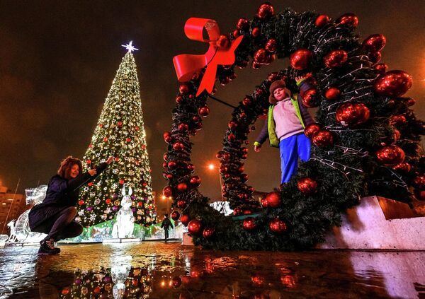 Горожане у новогодней елки на Октябрьской площади в Минске.