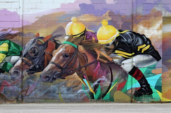 Мурал, на котором изображены чистокровные верховые лошади, на стене гоночного трека в канадском Торонто.