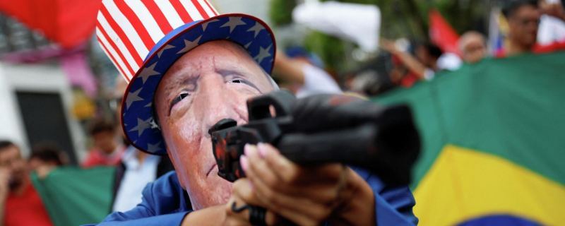 Мужчина в Маске Дональда Трампа на акции протеста против атаки США по Венесуэле