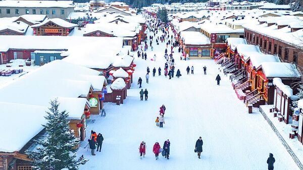 Туристы прогуливаются по китайскому Снежному городу - это одно из самых известных мест ледового и снежного туризма в китайской провинции Хэйлунцзян.