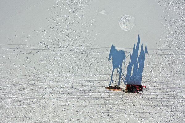 Дрон снял с высоты туристов во время прогулки на санях, запряженных лошадьми, по покрытому льдом озеру Чилдыр в провинции Ардахан, Турция.